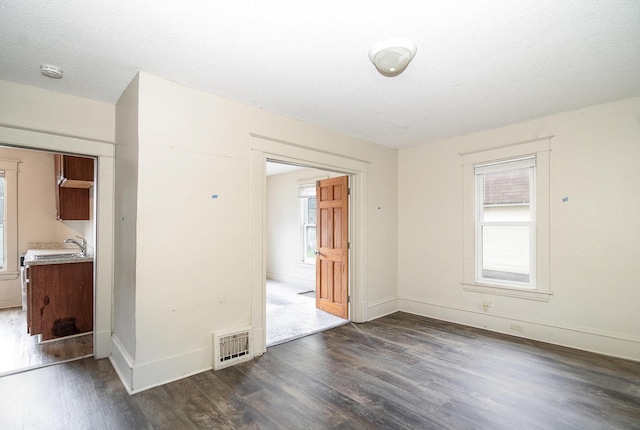 1040 26th Ave SE, Minneapolis, MN 55414 - spare room with plenty of natural light, visible vents, baseboards, and dark wood finished floors