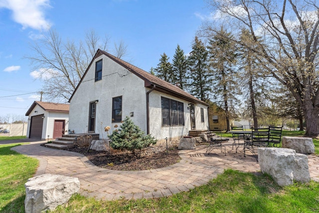 view of property exterior with a garage, stucco siding, and a patio area