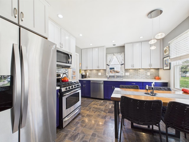 kitchen with light countertops, white cabinetry, tasteful backsplash, a sink, and stainless steel appliances