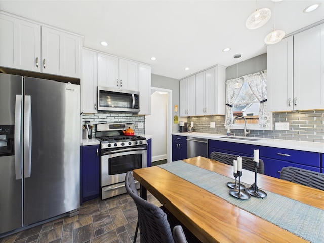 kitchen featuring white cabinets, a sink, light countertops, stainless steel appliances, and blue cabinets