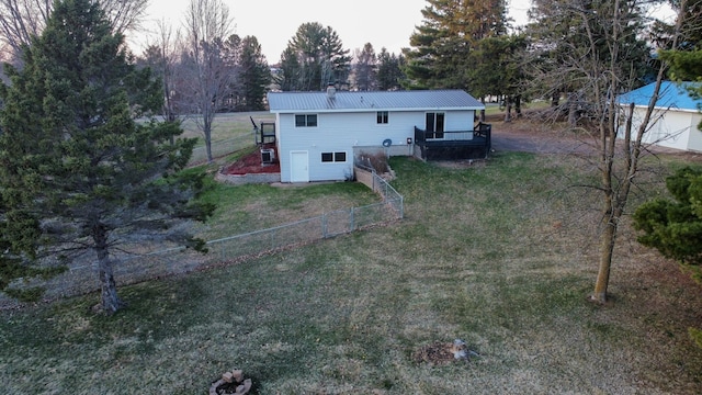 back of property featuring a wooden deck, metal roof, a yard, a fenced backyard, and a chimney