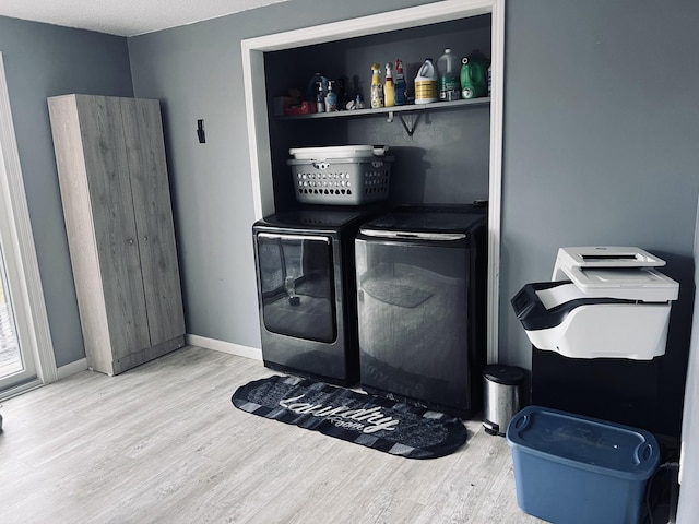 laundry area featuring wood finished floors, separate washer and dryer, laundry area, and baseboards