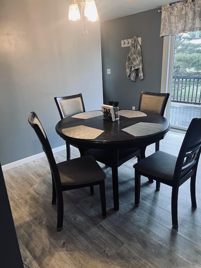 dining area featuring dark wood-style flooring and baseboards