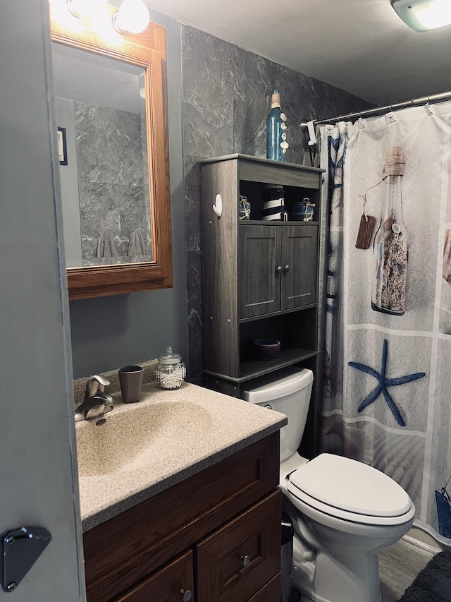 bathroom featuring toilet, a shower with curtain, and vanity