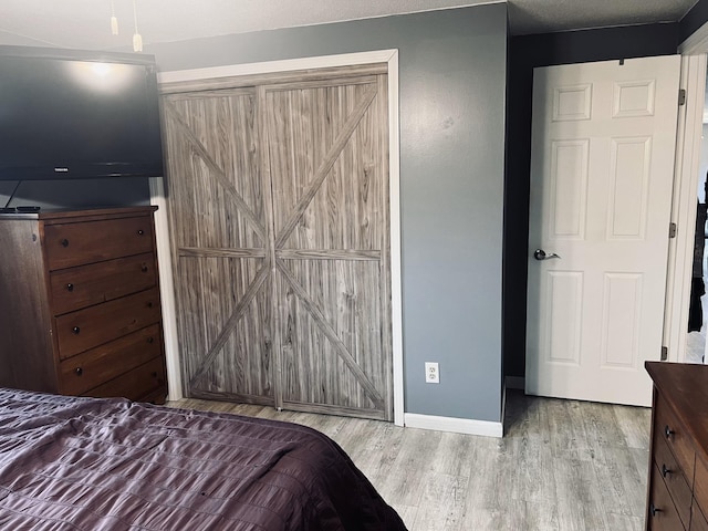 bedroom with baseboards and wood finished floors