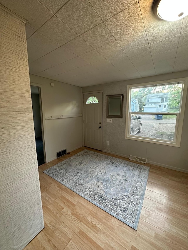 entryway featuring baseboards, visible vents, and wood finished floors