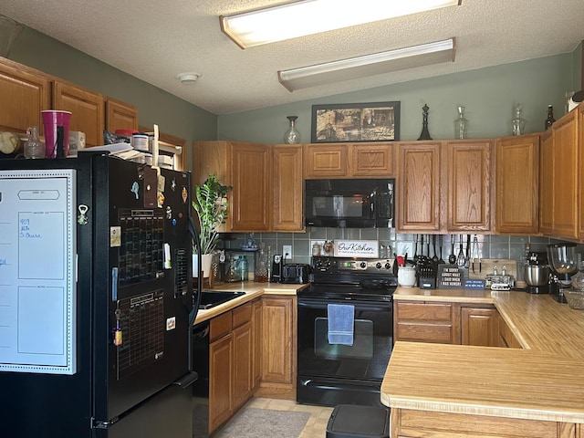 203 Colleen St SE, Remer, MN 56672 - kitchen featuring black appliances, light countertops, backsplash, brown cabinetry, and a textured ceiling