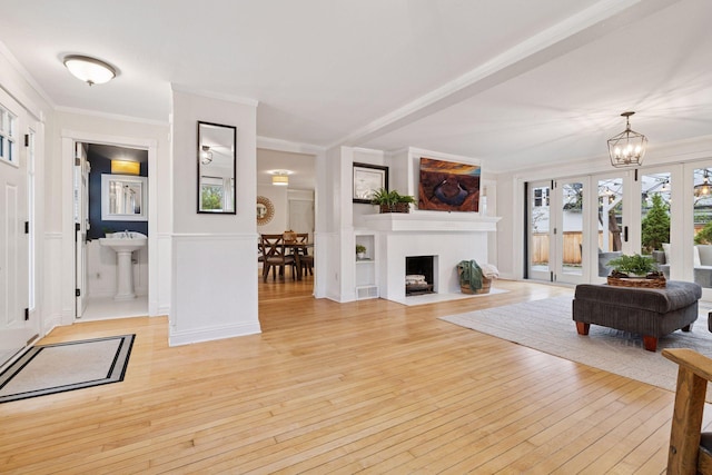 living room with crown molding, visible vents, and light wood-style flooring