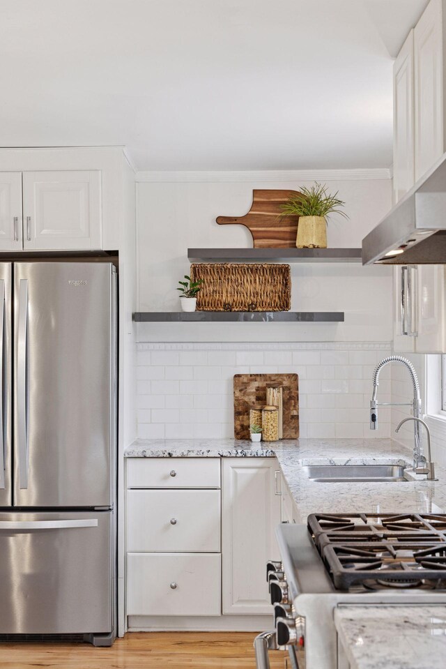 kitchen with a sink, open shelves, stainless steel appliances, and white cabinetry