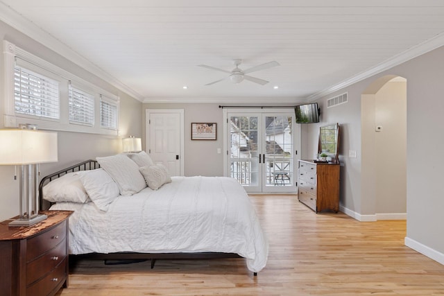 bedroom featuring access to outside, arched walkways, light wood-style flooring, baseboards, and visible vents