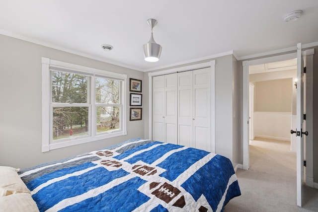 bedroom with light colored carpet, baseboards, crown molding, and a closet