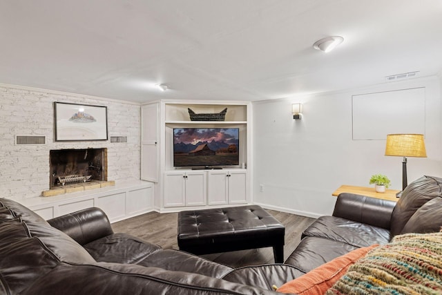living room with baseboards, visible vents, wood finished floors, and a fireplace