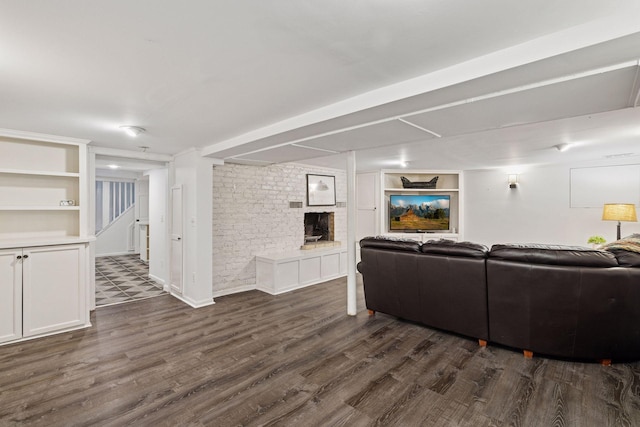 living room featuring baseboards, built in features, stairway, and dark wood-type flooring