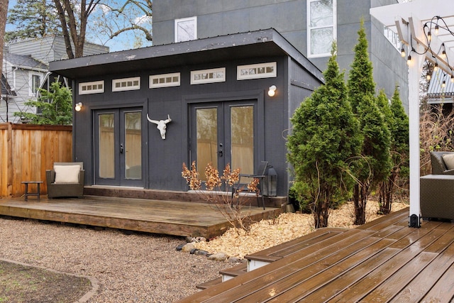 exterior space featuring french doors, fence, and a deck