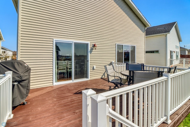 wooden terrace with outdoor dining space and area for grilling