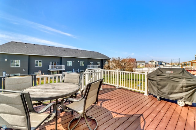 deck with grilling area, a residential view, and outdoor dining space