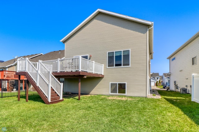 back of property featuring a lawn, a wooden deck, and stairs