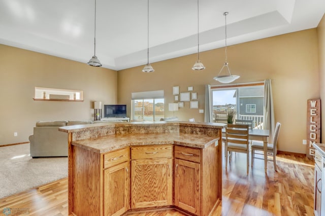 kitchen with a tray ceiling, open floor plan, and plenty of natural light
