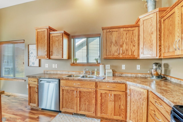 kitchen with a sink, light wood finished floors, dishwasher, light countertops, and visible vents