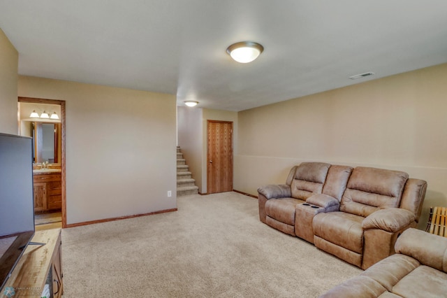 carpeted living room with baseboards, stairs, and visible vents