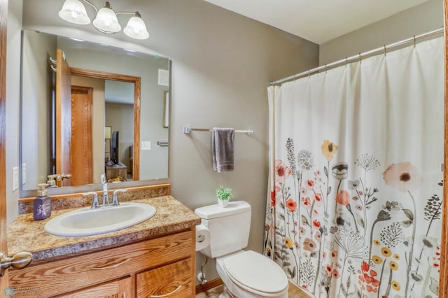full bath with vanity, a shower with curtain, toilet, and a chandelier