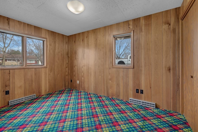 420 6th Ave N, Cold Spring, MN 56320 - unfurnished bedroom with wooden walls, visible vents, and carpet