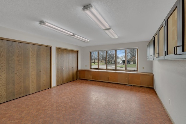 420 6th Ave N, Cold Spring, MN 56320 - unfurnished bedroom featuring a textured ceiling and multiple closets