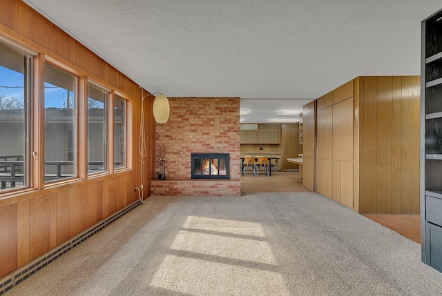 420 6th Ave N, Cold Spring, MN 56320 - unfurnished living room featuring wood walls, a fireplace, a textured ceiling, and carpet