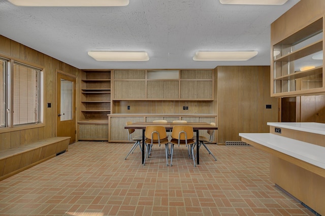 420 6th Ave N, Cold Spring, MN 56320 - dining room featuring a textured ceiling, wooden walls, and brick floor