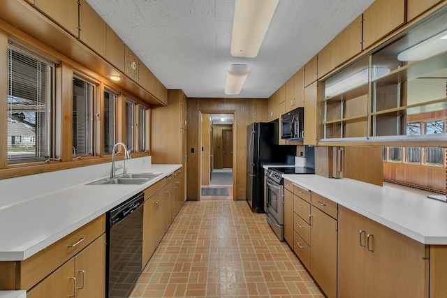 420 6th Ave N, Cold Spring, MN 56320 - kitchen with brown cabinets, a sink, light countertops, black appliances, and brick floor