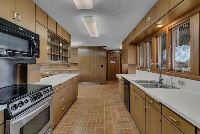 420 6th Ave N, Cold Spring, MN 56320 - kitchen with a sink, wood walls, light countertops, black appliances, and brick patterned floor