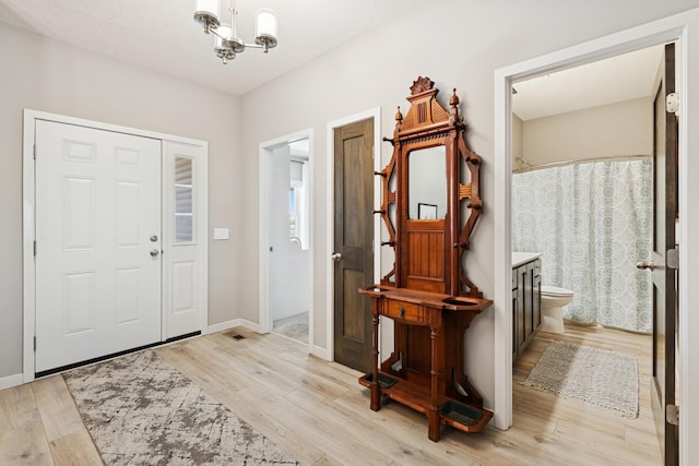 1703 11th St NE, Buffalo, MN 55313 - foyer featuring a chandelier, light wood-style floors, and baseboards