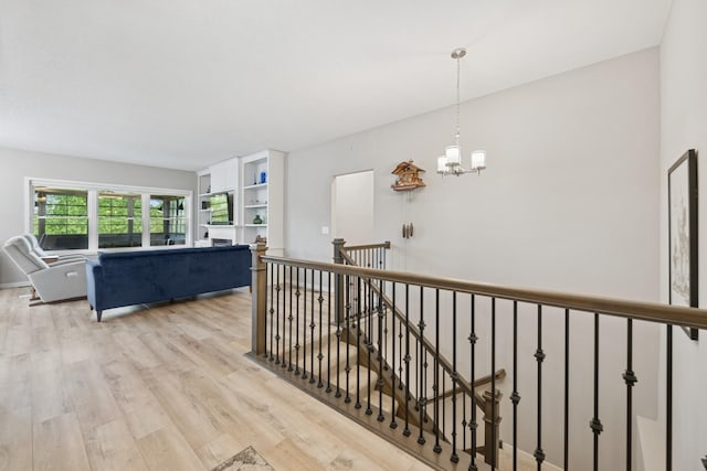 1703 11th St NE, Buffalo, MN 55313 - hallway with light wood-style flooring, a chandelier, and an upstairs landing