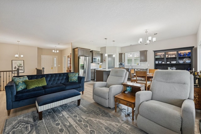 1703 11th St NE, Buffalo, MN 55313 - living room with a chandelier, light wood-style floors, and a textured ceiling
