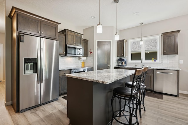 1703 11th St NE, Buffalo, MN 55313 - kitchen with stainless steel appliances, light wood-style floors, backsplash, dark brown cabinetry, and recessed lighting