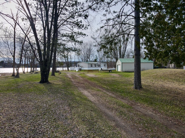 view of road featuring dirt driveway and a pole building