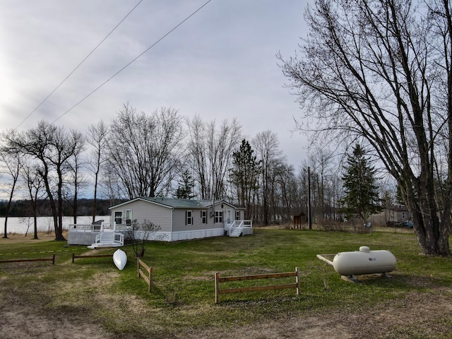 view of yard featuring fence and a water view