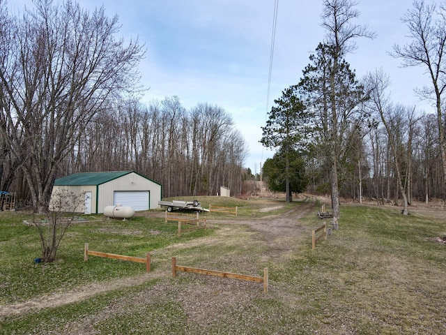 exterior space with an outdoor structure, a detached garage, and driveway