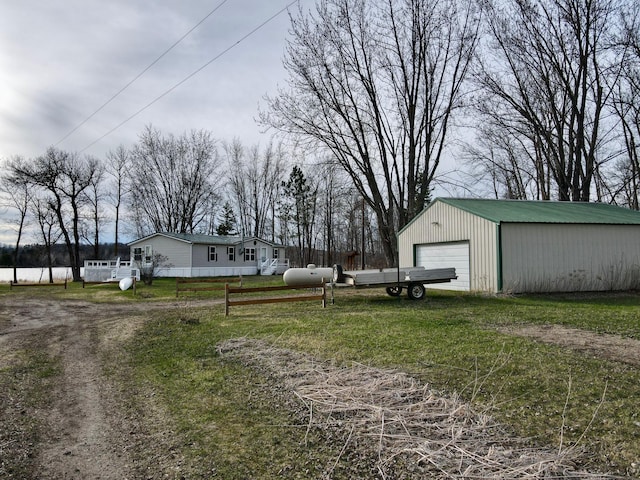 view of yard featuring fence, an outdoor structure, and a detached garage