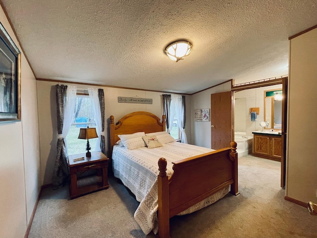 bedroom featuring ensuite bath, a textured ceiling, ornamental molding, and light carpet