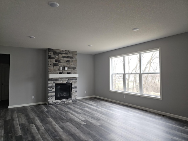 17121 61st St NE, Otsego, MN 55330 - unfurnished living room with dark wood-style flooring, a textured ceiling, baseboards, and a fireplace