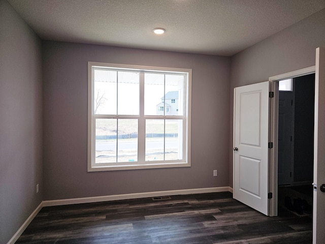 17121 61st St NE, Otsego, MN 55330 - spare room featuring baseboards, a textured ceiling, dark wood-style floors, and visible vents