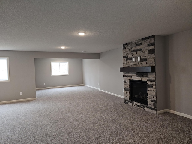 17121 61st St NE, Otsego, MN 55330 - unfurnished living room with a textured ceiling, baseboards, carpet flooring, and a stone fireplace