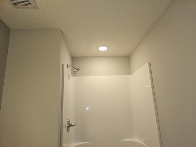 17121 61st St NE, Otsego, MN 55330 - bathroom with visible vents, a textured ceiling, and a shower