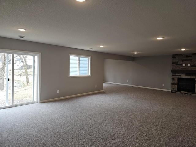 17121 61st St NE, Otsego, MN 55330 - unfurnished living room featuring a fireplace, baseboards, recessed lighting, a textured ceiling, and carpet