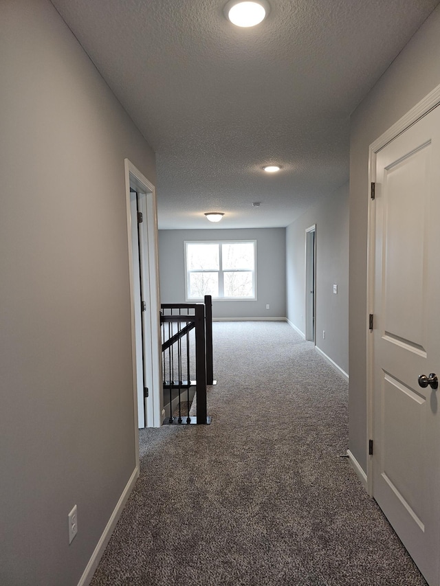 17121 61st St NE, Otsego, MN 55330 - hallway featuring carpet floors, a textured ceiling, an upstairs landing, and baseboards