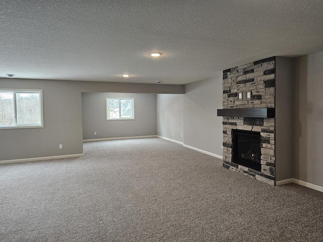 17121 61st St NE, Otsego, MN 55330 - unfurnished living room with a textured ceiling, baseboards, carpet flooring, and a stone fireplace