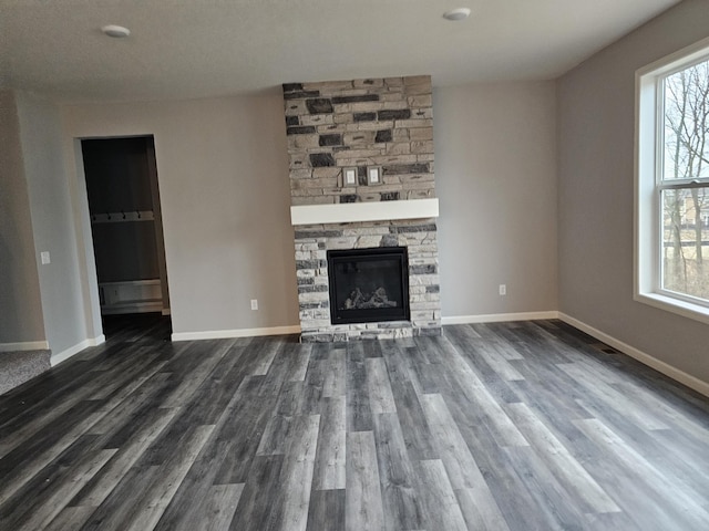 17121 61st St NE, Otsego, MN 55330 - unfurnished living room with plenty of natural light, dark wood-style flooring, and a stone fireplace