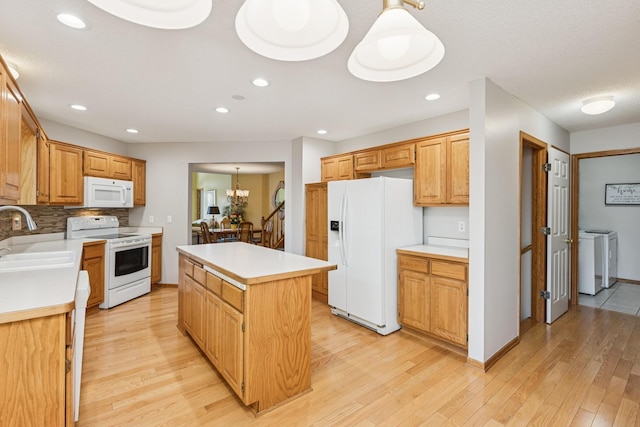 3662 Pond View Pt, Eagan, MN 55122 - kitchen with white appliances, a sink, a kitchen island, light wood-style flooring, and light countertops