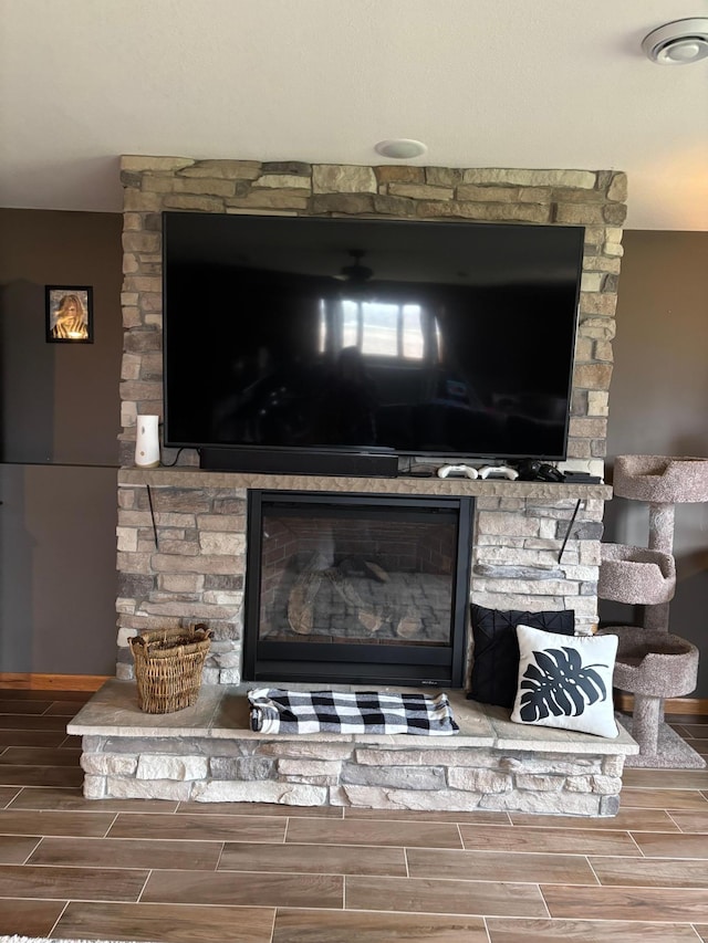 interior details with wood tiled floor, baseboards, and a fireplace